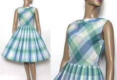 "This 1950's dress combines fun and fashion.  What more could a girl want, right?  It's made of a lightweight cotton with a darling plaid pattern consisting of white with pastel blues and greens.  It has a two tiered shawl collar and gathers at the waistline to create a full skirt that is both fun and flirty.  The dress closes on the side with a nylon zipper.  My guess is this was homemade but it's so adorable and in excellent condition! Measurements are: B - 34\"   W - 26\" Hips - full Overall Length - 40\"   Please read my shop policies as I don't accept returns. Should you have any questions please feel free to email me and I will reply.   If you mark my shop as a favorite you will be able to see my updates." Retro Dresses For Spring Retro-themed Events, Spring Retro Dresses For Retro-themed Events, 1950s Style Dresses For Retro-themed Spring Events, Retro Blue Dress For Picnic, Spring Sleeveless Dress For Retro-themed Events, 1950s Style Blue Spring Dress, Vintage Fitted Pastel Dresses, Fitted Vintage Dresses In Pastel Colors, Fitted Vintage Dress In Pastel