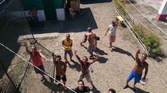 a group of people standing on top of a dirt field next to each other holding tennis racquets