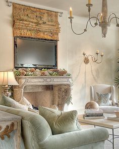 a living room filled with furniture and a flat screen tv mounted to the wall above a fireplace