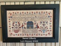 a cross stitch sample with the words sweet liberty on it and an image of a house