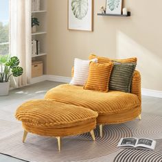 a living room with a yellow couch and pillows on the floor next to a book shelf