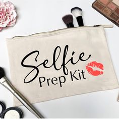 a makeup bag with the words selfie prep kit on it next to cosmetics and flowers