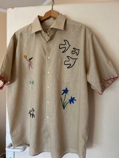 Unisex cotton linen shirt;  One size with hand embroidery motif on the front over the shirt, on the edges of the sleeves. Hand-embroidered signature on the back 🩰 Upper chest pocket open Embroidered Relaxed Fit Shirt For Summer, Summer Embroidered Relaxed Fit Shirt, Casual Embroidered Linen Tops, Traditional Linen Shirt For Spring, Embroidered Linen Tops With Relaxed Fit, Summer Cotton Embroidered Shirt, Summer Embroidered Cotton Shirt, Beige Embroidered Linen Top, Embroidered Beige Linen Top