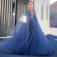 Luxury Blue A-Line Evening Dress with Cape Sleeves - Women's Party Gown 2024 Glamorous Blue Ball Gown For Evening, Glamorous Blue Evening Ball Gown, Blue Embellished Ball Gown For Evening, Blue Embellished Evening Ball Gown, Prom Gown With Sweep Train And Cape Sleeves, Luxury Blue Evening Dress With Sweep Train, Luxury Blue Gown For Prom Season, Luxury Blue Gown For Banquet, Elegant Blue Evening Dress With Cape Sleeves