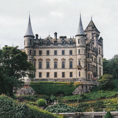 an old castle sitting on top of a lush green hillside