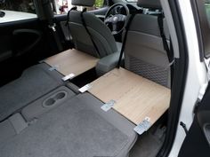 the interior of a small car with seats folded down and wooden flooring on the side