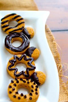 a white plate topped with donuts covered in chocolate