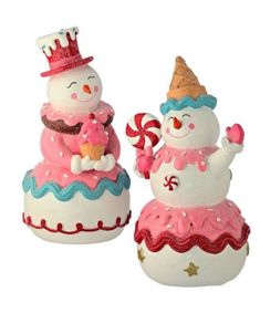 two snowmen sitting on top of each other wearing hats and holding candy canes