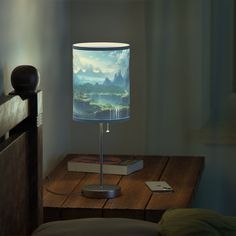 a lamp that is sitting on top of a table next to a book and phone