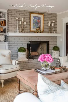 a living room filled with furniture and a fire place in front of a brick wall