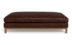 a brown leather ottoman sitting on top of a wooden frame