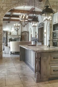 a kitchen with an island and chandelier hanging from the ceiling