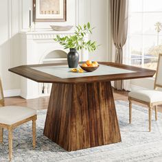 a dining room table with two chairs and a bowl of fruit on the center piece