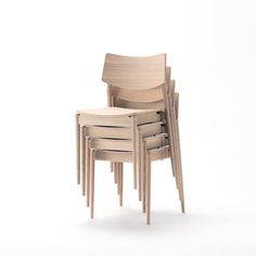 a stack of four wooden chairs sitting next to each other on top of a white floor