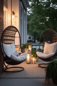 two hanging chairs on a porch with candles