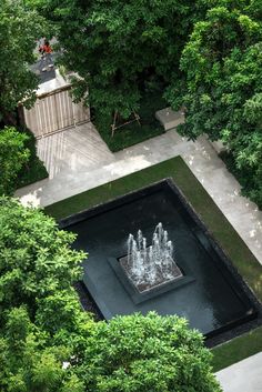 an aerial view of a fountain surrounded by trees