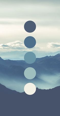 the sky is filled with white and blue circles in front of some mountains on a cloudy day