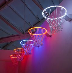 three basketball hoops are lit up in the dark