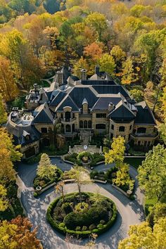 an aerial view of a large mansion surrounded by trees and shrubs in the fall season