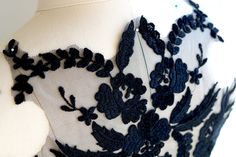 a black and white dress with blue flowers on the front, sitting on a mannequin