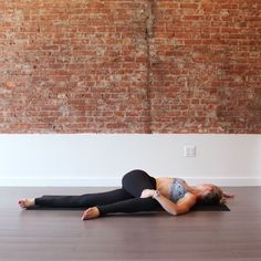 a woman is laying on the floor doing yoga