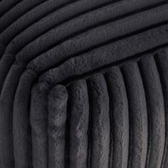 an image of the back end of a bed made out of black sheepskins