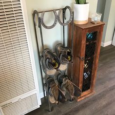 there are many pairs of shoes on the floor next to a rack with sandals and a potted plant