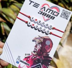 a person holding up a card with an iron man image on it