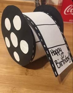 a roll of toilet paper with a happy birthday tag on it sitting on top of a wooden table