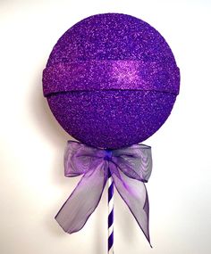 a purple lollipop with a bow on it