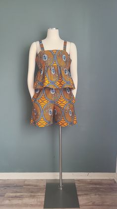 This African print cotton set features a sleeveless top and paper bag waist shorts with side pockets.  Fit: Regular Details: thick straps, empire waistline, shorts with inseam side pockets, elasticated waistband Garments Measurements: Top: Bust: Bust 36 in                    Waist: Free                     Hips: Free                                       Full Length: 20 in Shorts: Waist: 26 in                Hips: 40 in                Full Length: 19 in Fits:  Medium  Bust: 34-36 in /  Waist: 26 Ankara Print, African Ankara, Empire Waistline, Cotton Set, Drawstring Pants, Shorts Set, Set For Women, African Print, Empire Waist