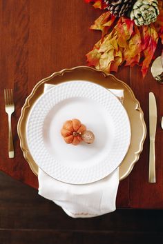 a white plate sitting on top of a wooden table next to a fork and knife