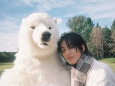 a woman poses with a large white polar bear