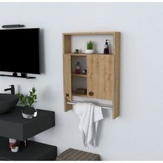 a bathroom with a sink, mirror and television mounted on the wall next to it