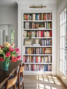 a room filled with lots of books and flowers