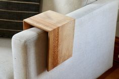 a close up of a couch with a wooden frame on the armrest and back