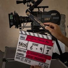 a person holding a clapper in front of a camera