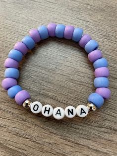 Ohana means family with this handmade beaded stretch bracelet made with varying shades of purple and blue plastic pastel pony beads. Our favorite experiment from another planet shows us what family is all about with this Hawaiian inspired stackable piece.  Bracelets are available in a variety of lengths.  Pick your custom length from the drop down menu below.  All our bracelets are made with quality in mind.  With that being said, all bracelets should be treated with care while putting on, weari Beaded Bracelets Pony Beads, Hawaiian Clay Bead Bracelets, Bracelet Ideas Plastic Beads, Stitch Bracelet Ideas, Disney Themed Beaded Bracelet, Disney World Friendship Bracelet, Plastic Bead Bracelet Ideas, Friendship Bracelets Disney, Pony Beads Bracelet Ideas