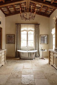 a bathroom with a claw foot tub and chandelier in the middle of it