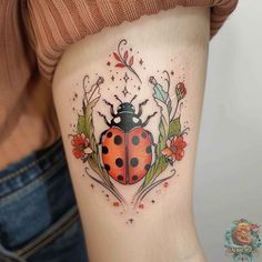 a ladybug tattoo on the thigh