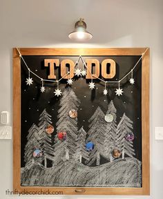 a chalk board with the words to do written on it in front of christmas trees