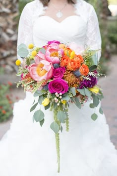 a bride holding a colorful bouquet in her hand