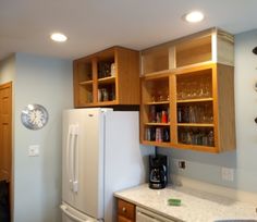 a white refrigerator freezer sitting inside of a kitchen next to wooden cupboards and counter tops