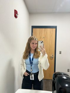 a woman taking a selfie in front of a mirror