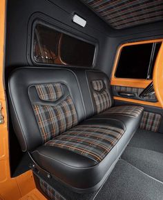 the interior of an orange and black car with plaid upholstered seat covers on it