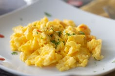 scrambled eggs on a white plate with parsley