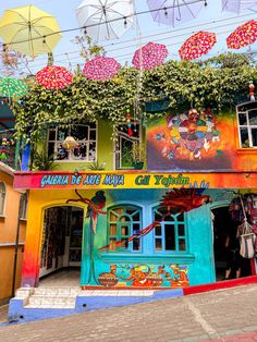 the colorful building has many umbrellas above it