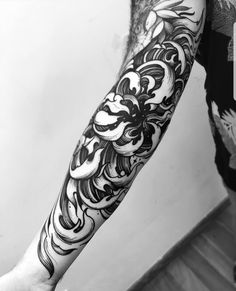 a man's arm with black and white tattoo designs on the forearm, hand and leg