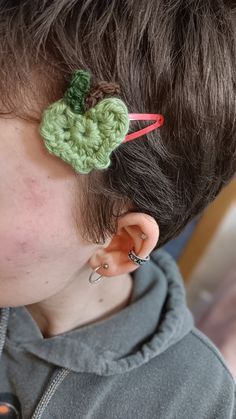 a close up of a person wearing a pair of ear clips with a crocheted flower in the middle