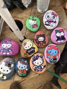 hello kitty painted rocks on a wooden table